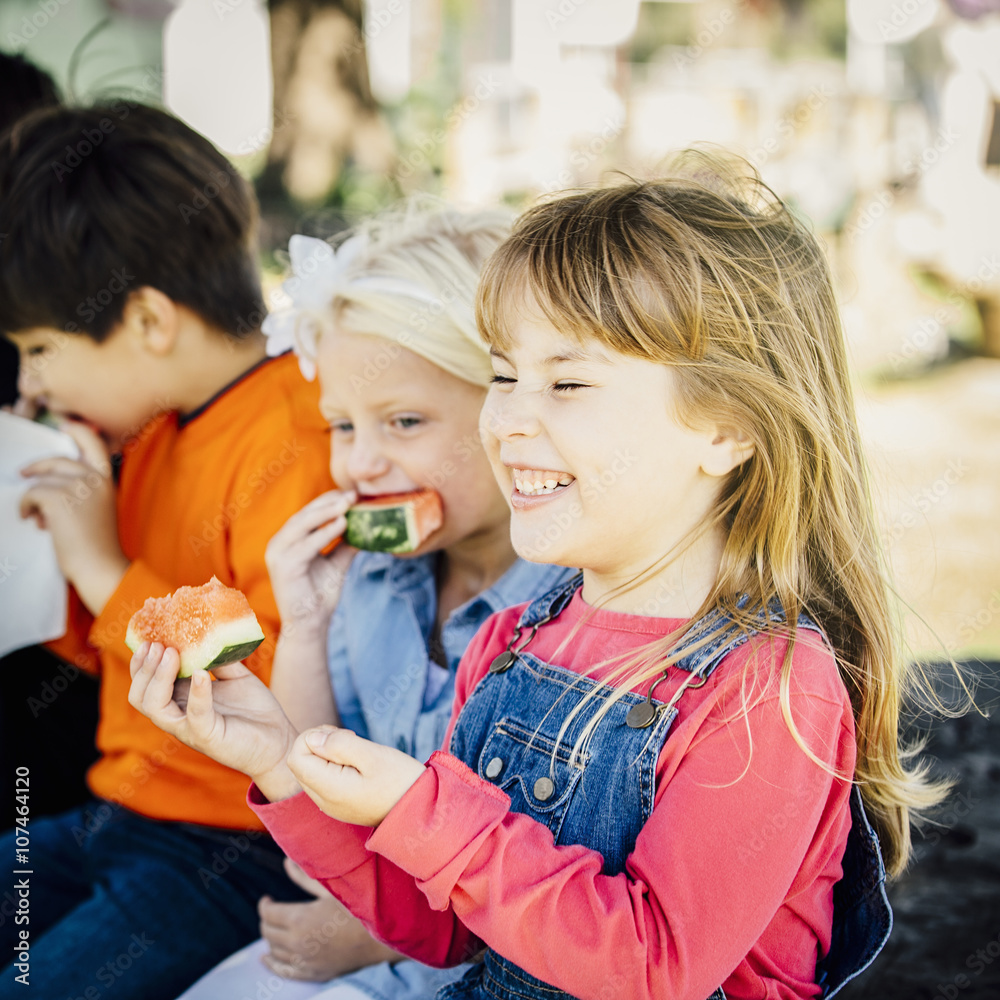 Caucasian children eating watermelon outdoors Caucasian children eating watermelon outdoors