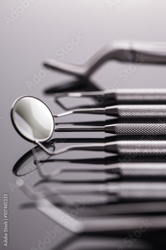 Dental mirror and other tools on shiny table