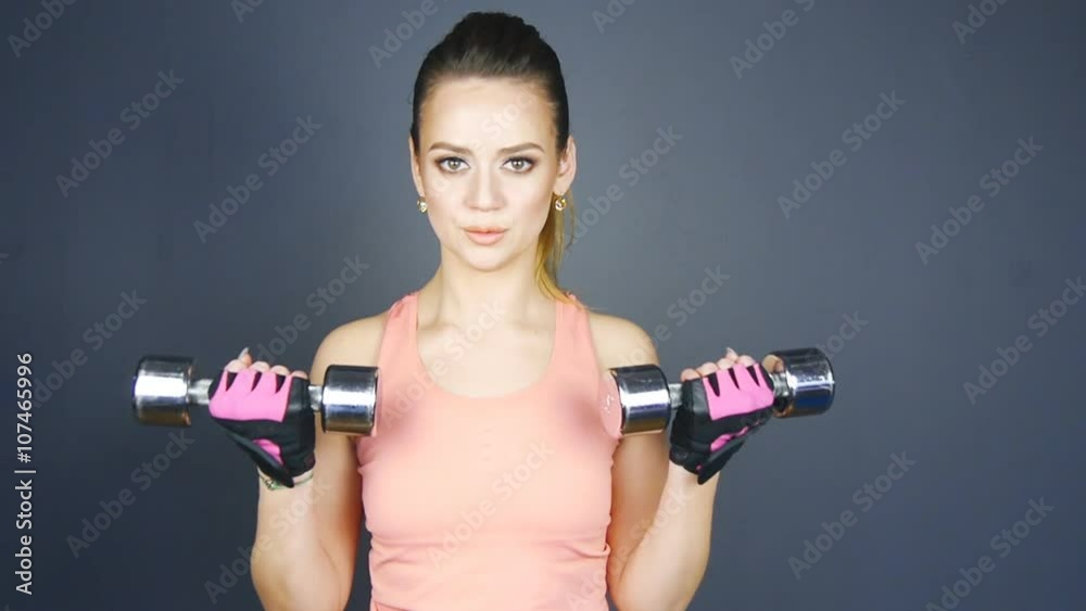 Fitness girl with dumbbells in slowmotion Fitness girl with dumbbells in slowmotion