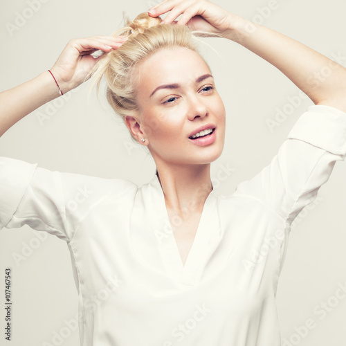 Blond cheerful young woman. Beauty portrait, perfect makeup. Model tests. Young girl in white.