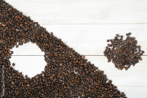 Top view of coffee beans making a modified symbol Yin yang with border diagonally 