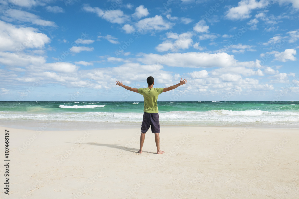young man enjoying freedom on a tropical beach young man enjoying freedom on a tropical beach
