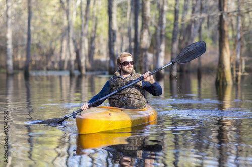 Caucasian man rowing canoe in river photo