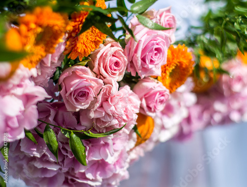 Colorful wedding decoration with pink roses and peonies and orange gerbera