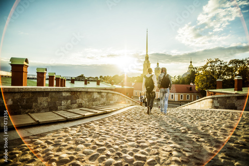 Caucasian tourists walking on cobblestone Leningrad street, Leningrad, Russia photo