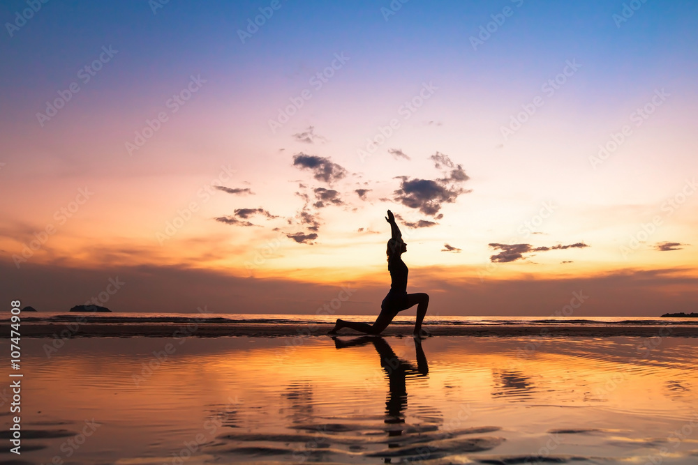 beautiful yoga exercise on the beach at sunset, background with copyspace