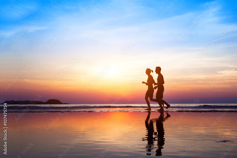 workout background, two people jogging on the beach at sunset, runners silhouettes, healthy lifestyle concept