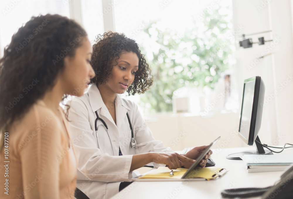 Doctor and patient using digital tablet in clinic Doctor and patient using digital tablet in clinic