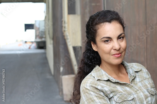Beautiful woman in her forties wearing a casual plaid shirt in urban background
