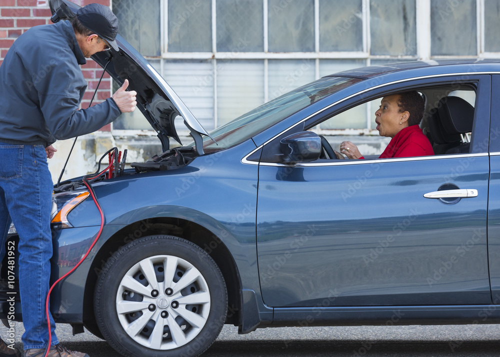 Mechanic jumping battery for woman in car Mechanic jumping battery for woman in car