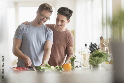 Caucasian gay couple cooking in kitchen