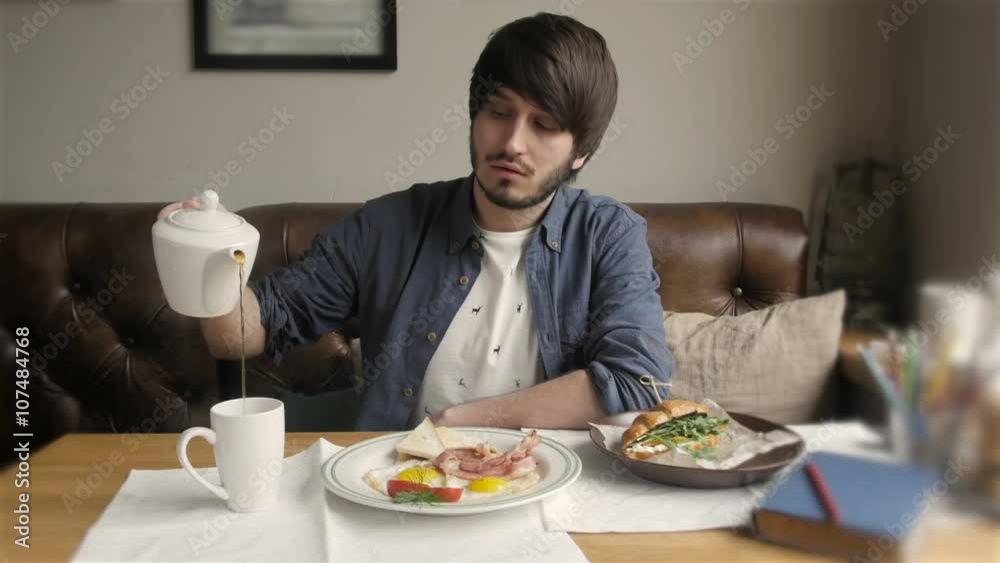 Cinemagraph of Young Handsome Man Serving Tea in Modern Cafe Cinemagraph of Young Handsome Man Serving Tea in Modern Cafe