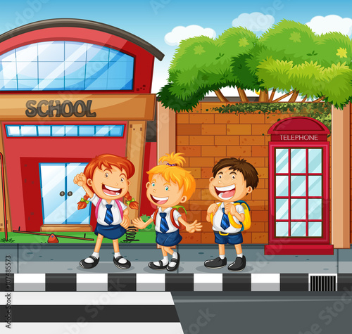 Three students waiting to cross the road