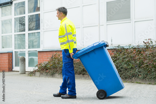 Εκτύπωση καμβά Male Worker Walking With Dustbin On Street