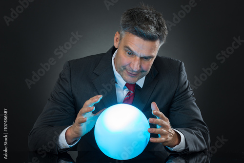 Billede på lærred Portrait Of Businessman Predicting Future With Crystal Ball