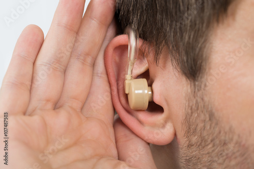 Close-up Of Man Wearing Hearing Aid In Ear