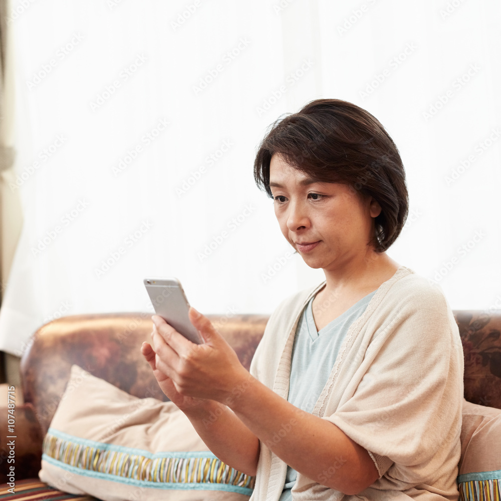 携帯電話を使うミドル女性