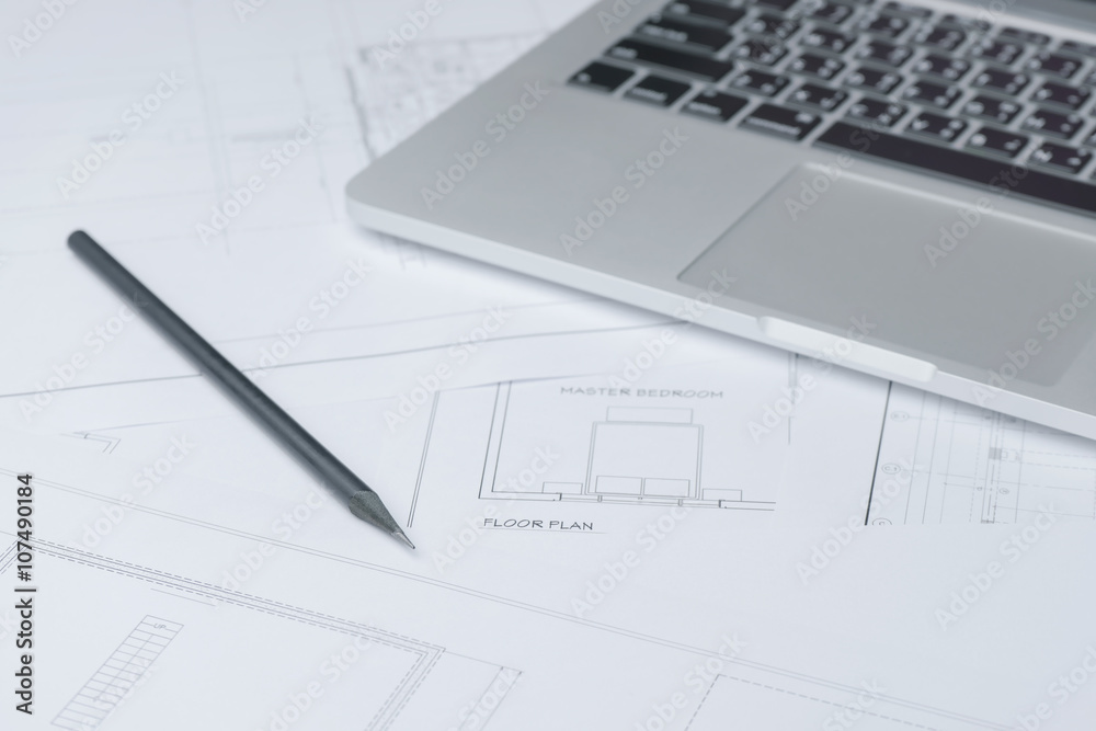 black pencil and computer laptop on architectural drawing paper for construction