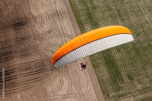 aerial view of paramotor flying over the fields photo