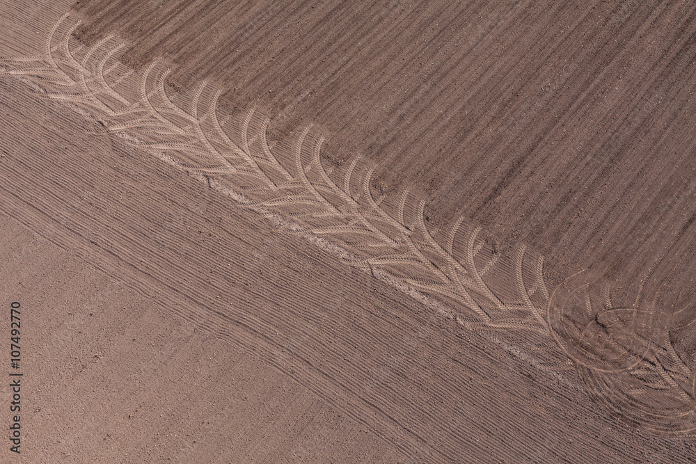 Naklejka premium aerial view of tractor tracks on harvest field