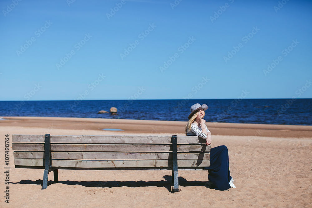 girl sitting on a bench on the beach