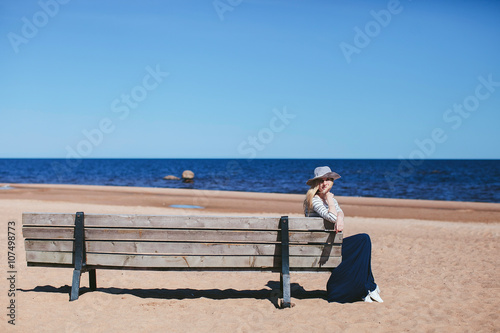 girl sitting on a bench on the beach © stock.film