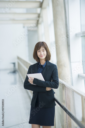 Attractive asian business woman working on tablet computer outsi