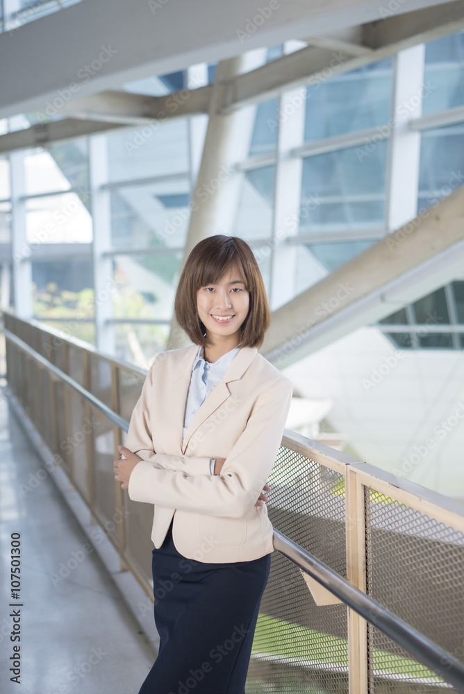 Attractive asian business woman smiling outside office Attractive asian business woman smiling outside office