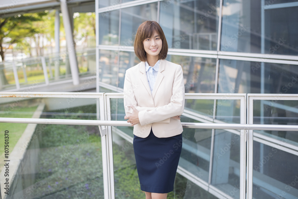 Attractive asian business woman smiling outside office Attractive asian business woman smiling outside office