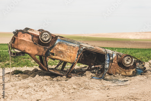 Abandoned rusty burnt car wreck.