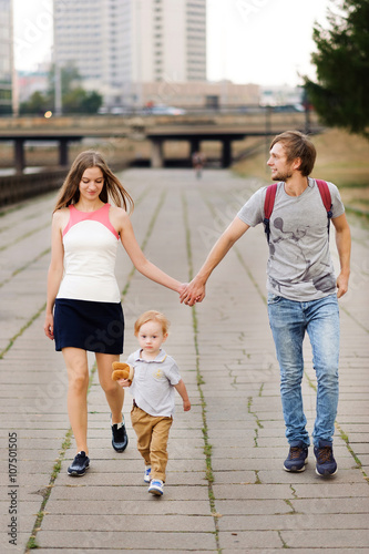 A young and happy family relaxing in the park with his young son