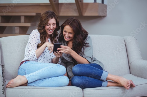 Two beautiful women looking at the mobile phone