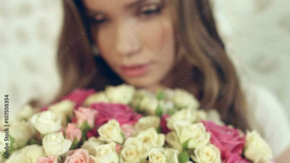 Dreamy girl sniffs a huge bouquet of roses Dreamy girl sniffs a huge bouquet of roses