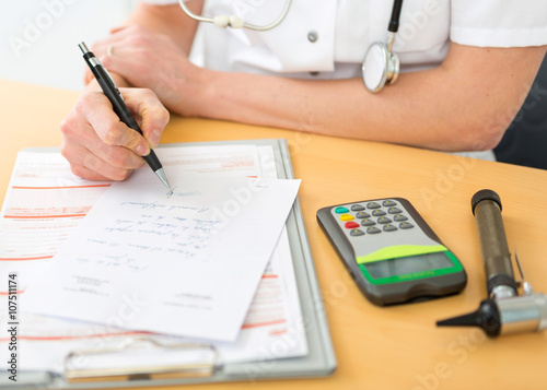 Close up viewof a doctor filling a prescription to a patient