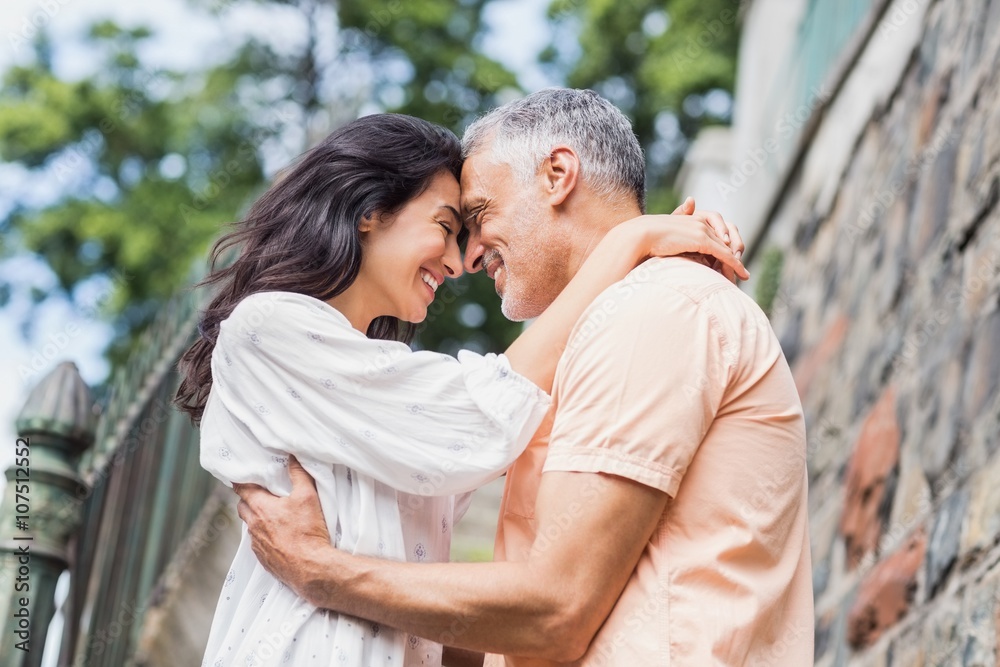 Side view of happy couple standing head to head Side view of happy couple standing head to head