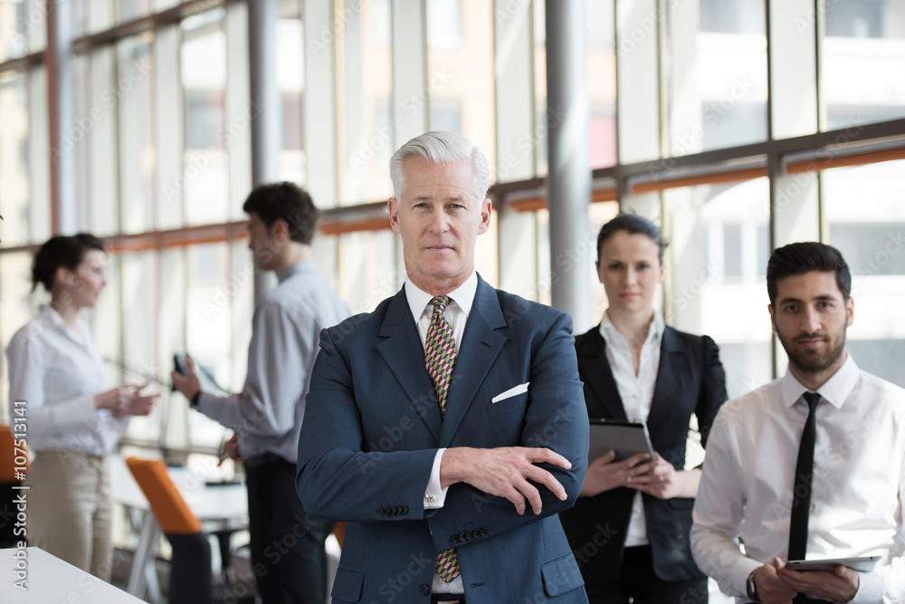 portrait of senior businessman as leader  with group of people i