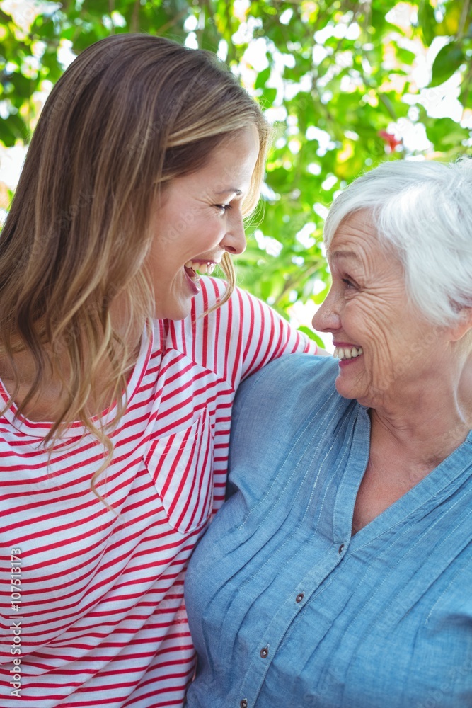 Cheerful mother and daughter with arm around Cheerful mother and daughter with arm around