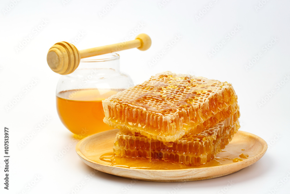 Honeycomb with jar and honey dipper isolated on white background Honeycomb with jar and honey dipper isolated on white background