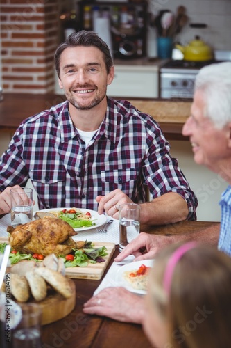 Smiling father sitting at dining table 