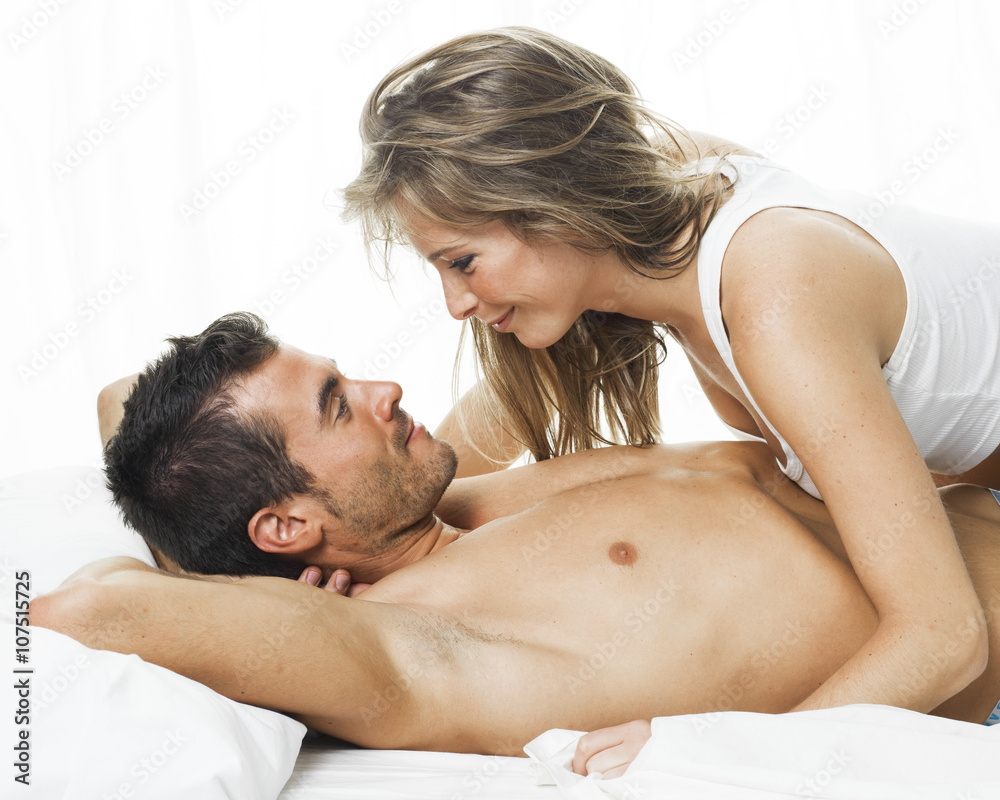 attractive couple in love under white bed sheets attractive couple in love under white bed sheets