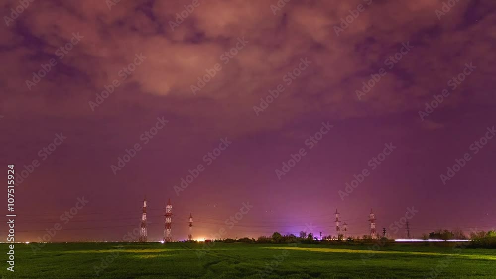 Electric poles on a field at night Electric poles on a field at night