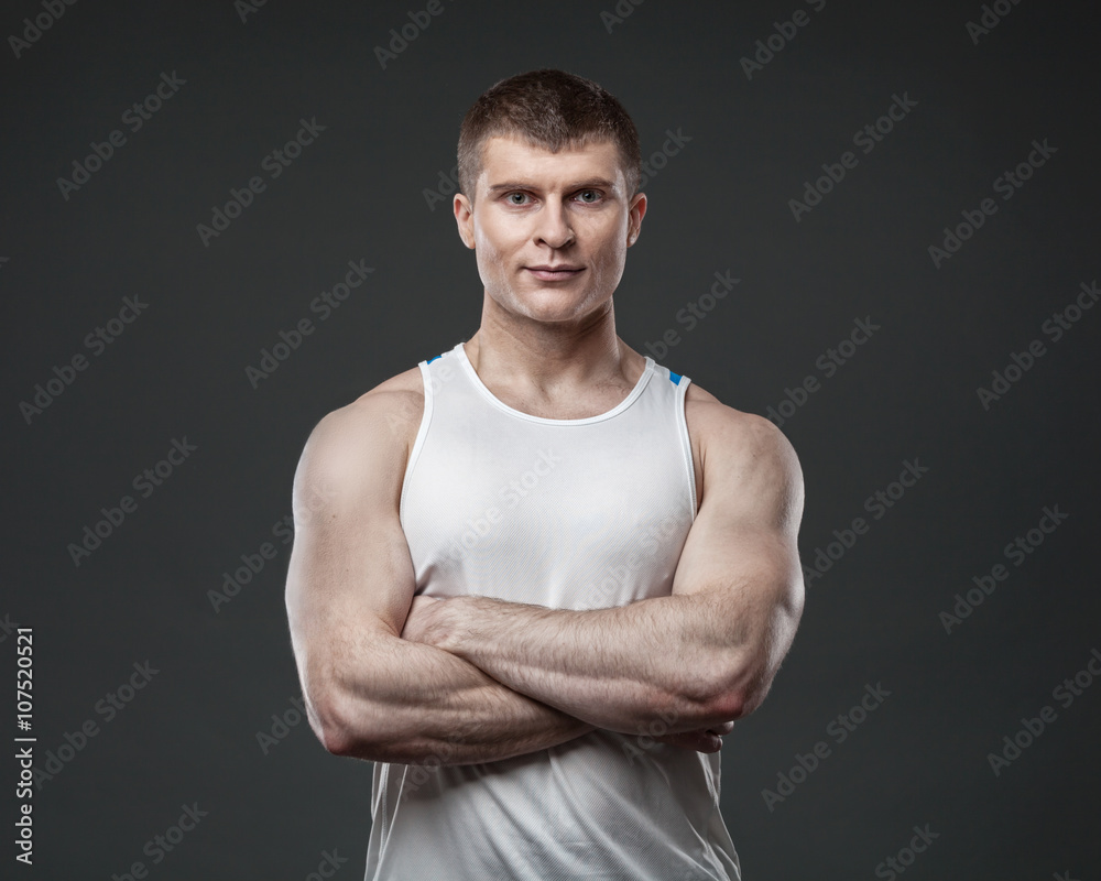 Young muscular man isolated on gray background Young muscular man isolated on gray background