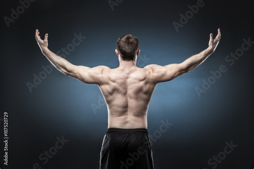 Muscular male back isolated on dark blue background