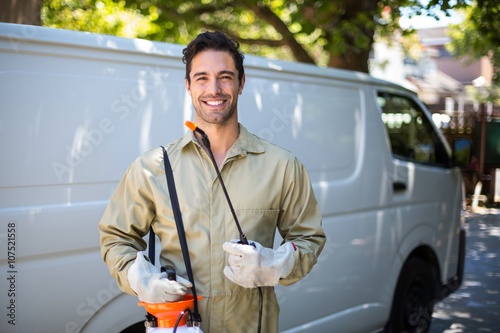 Smiling worker with pesticide sprayer photo