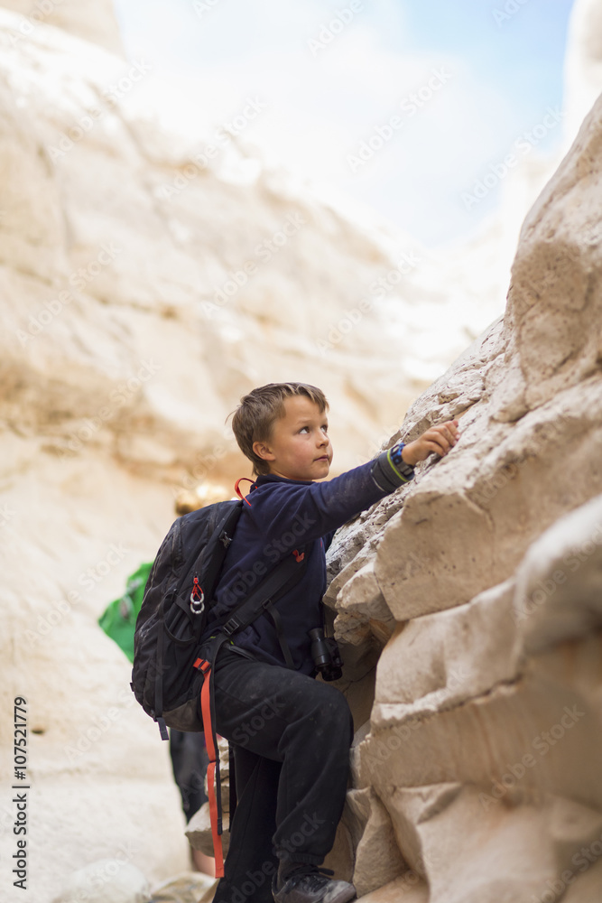 Boy climbing desert rock formations Boy climbing desert rock formations
