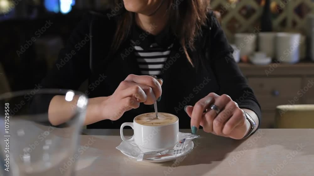 attractive brunette sits at a bar and drinking coffee. Great mood, she laughs attractive brunette sits at a bar and drinking coffee. Great mood, she laughs