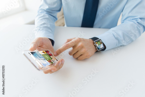 close up of hands with smart phone and watch