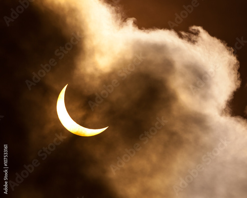 Partial solar eclipse through clouds