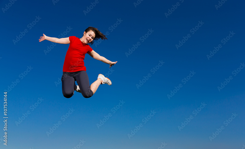 Teenage girl jumping outdoor against blue sky