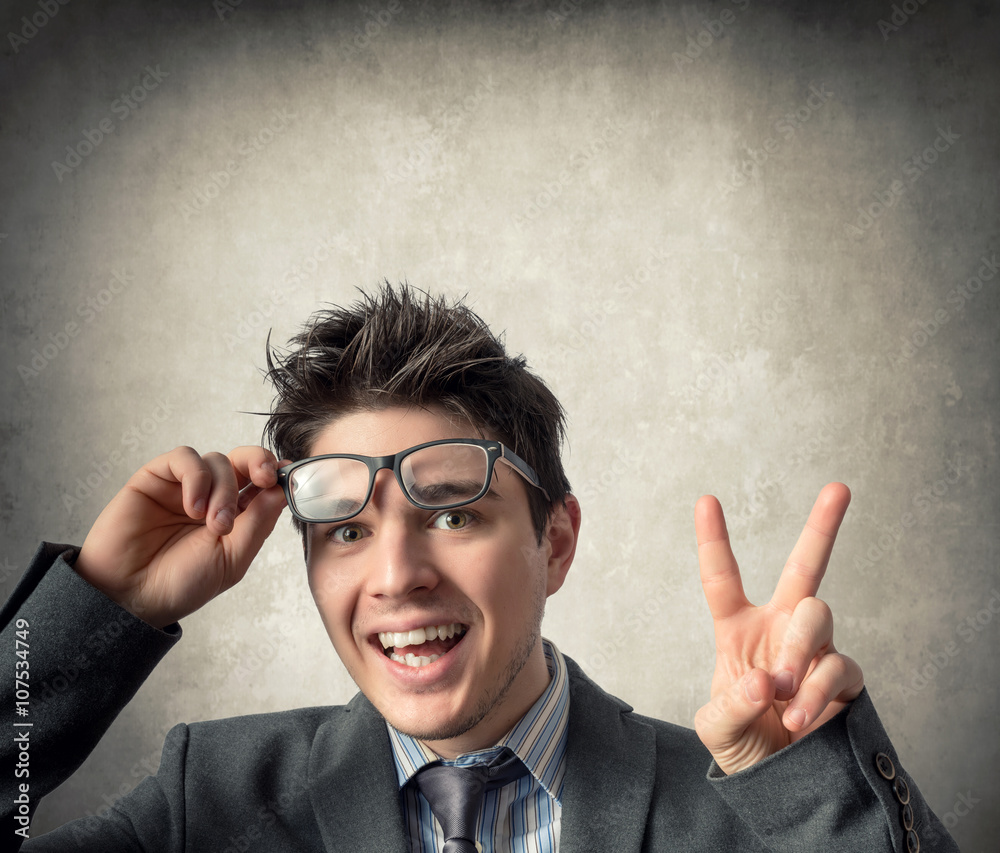 Young happy businessman who makes the victory sign StockFoto Adobe Stock